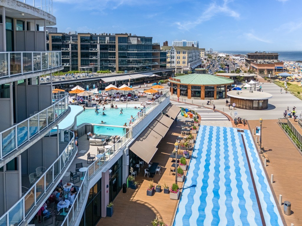 A large outdoor pool area with people enjoying the sunny day.