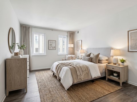 Cozy bedroom with light wood furniture and layered bedding at The at Elmwood Terrace Apartments, Frederick, MD 21702