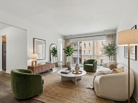 A living room with a green chair, a white sofa, and a coffee table.