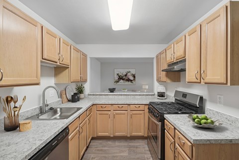 A kitchen with wooden cabinets and granite countertops.