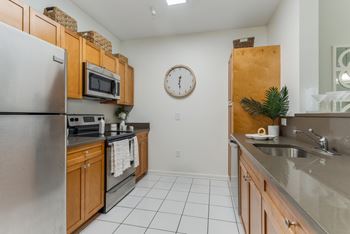 A kitchen with a refrigerator, microwave, and oven.
