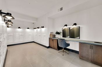 A modern office space with a desk, chairs, and mounted monitors.