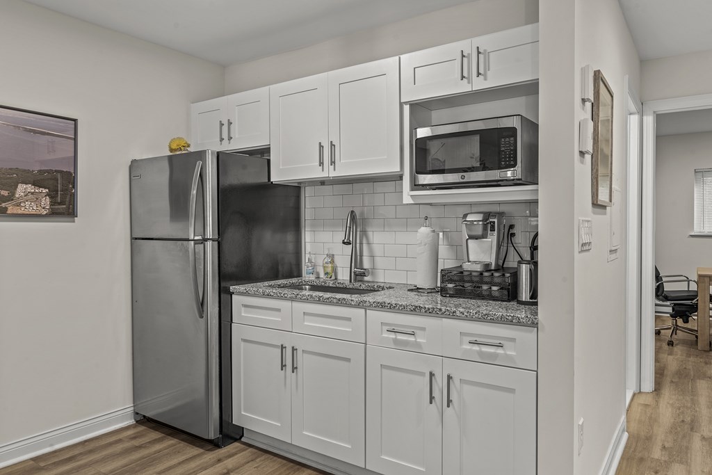 A kitchen with a refrigerator, microwave, and cabinets at Atlantic Pointe Apartments, Atlantic Highlands, NJ