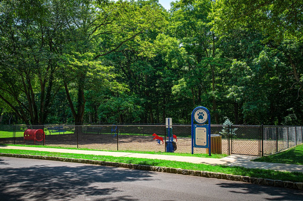 A sign with a dog on it stands in front of a fence at Atlantic Pointe Apartments, Atlantic Highlands  at Atlantic Pointe Apartments, New Jersey 