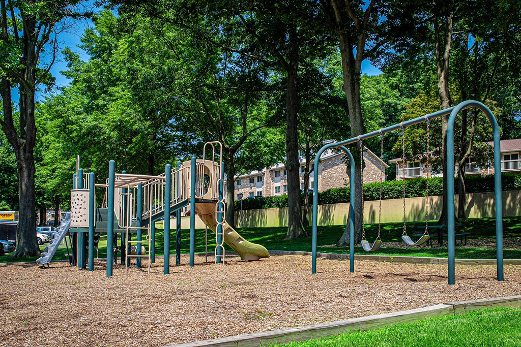 A playground with a slide, swings, and a climbing frame at Atlantic Pointe Apartments, Atlantic Highlands New Jersey 