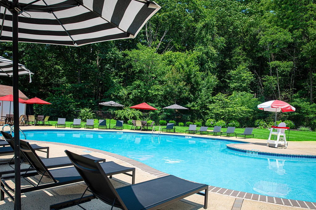 A pool with a striped umbrella at Atlantic Pointe Apartments, Atlantic Highlands, NJ