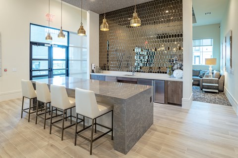 a kitchen with a marble counter top and white chairs