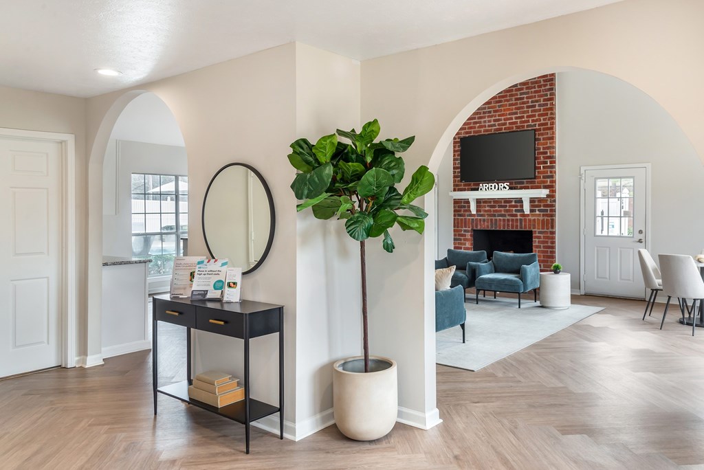 A living room with a brick fireplace and a television above it.