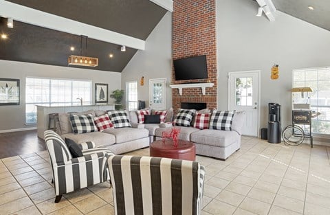 a living room with couches and chairs and a brick fireplace