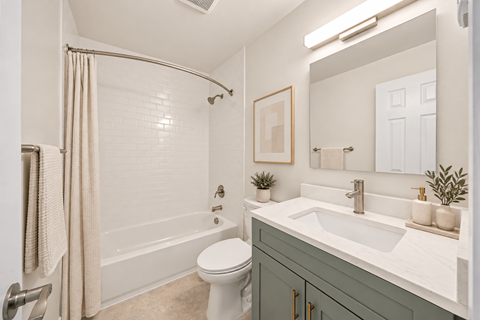 A white bathroom with a toilet, sink, and shower.