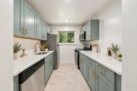 A kitchen with teal cabinets and white countertops.
