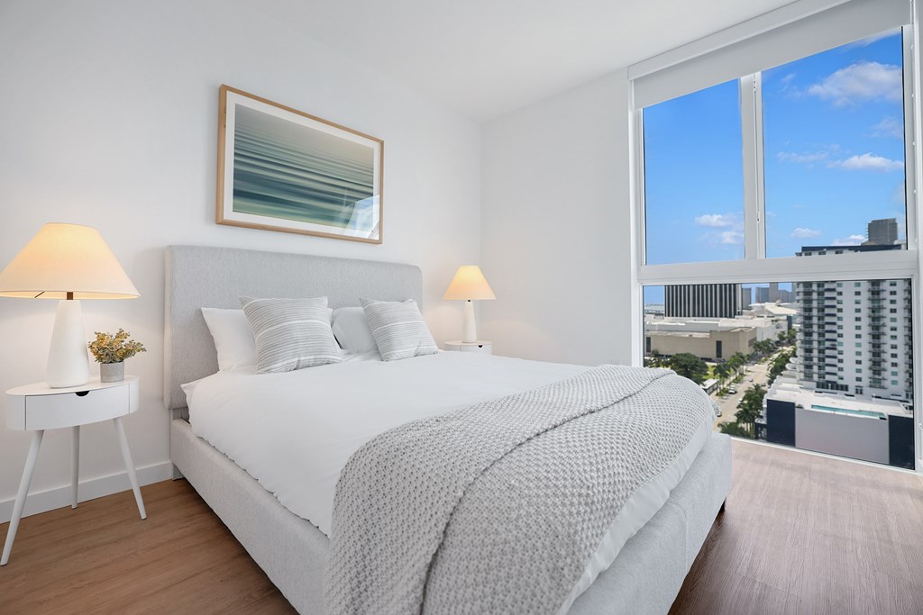 a bedroom with a bed and a large window
