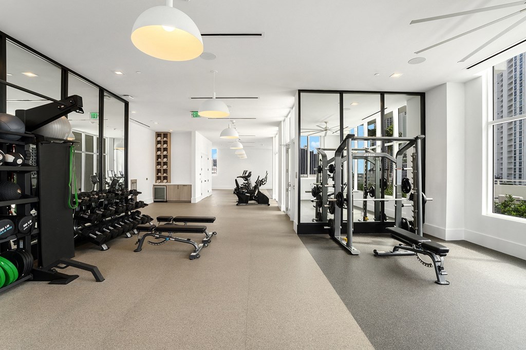 a workout room with weights and glass windows