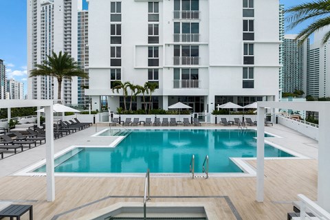 a large swimming pool in front of a tall building