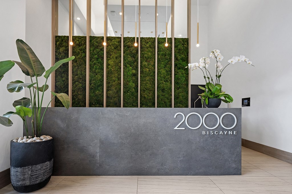 a reception area with a large metal sign with the company logo