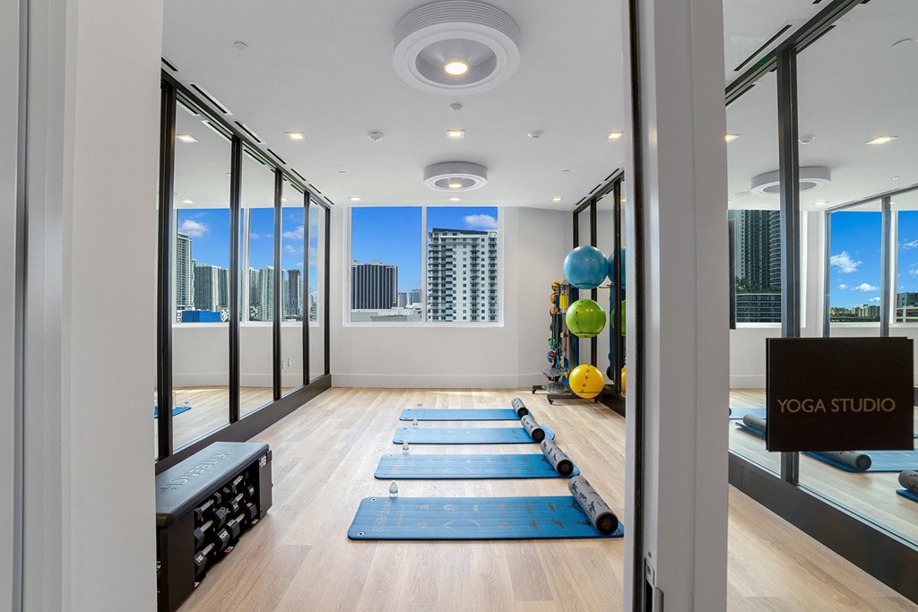 a yoga studio with yoga mats and a view of the city