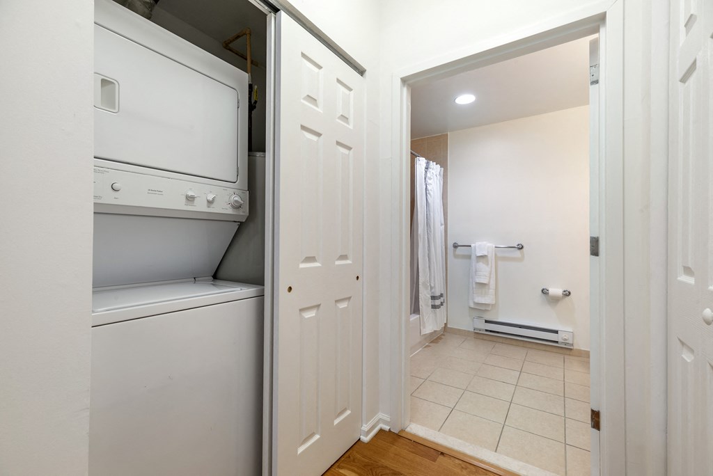 a laundry room with a washer and dryer and a door to a bathroom at Pier Village Apartments, Long Branch, 07740