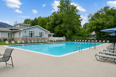 A pool with a house in the background.