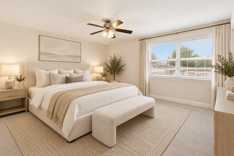 A bedroom with a large bed and a ceiling fan.