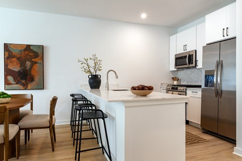 A kitchen with a white counter and a painting on the wall.