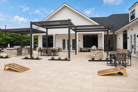 A patio area with a white building and black furniture.