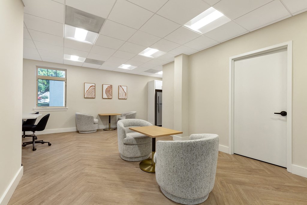 a waiting room with chairs and a table in front of a door at Copper and Quarry Village, Pikesville, 21209