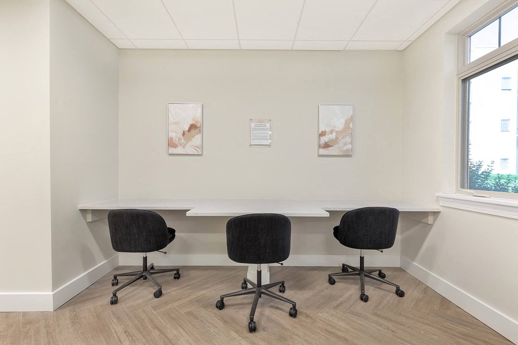 a conference room with a table and chairs and two paintings on the wall at Copper and Quarry Village, Maryland, 21209