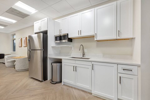 a kitchen with white cabinets and a stainless steel refrigerator