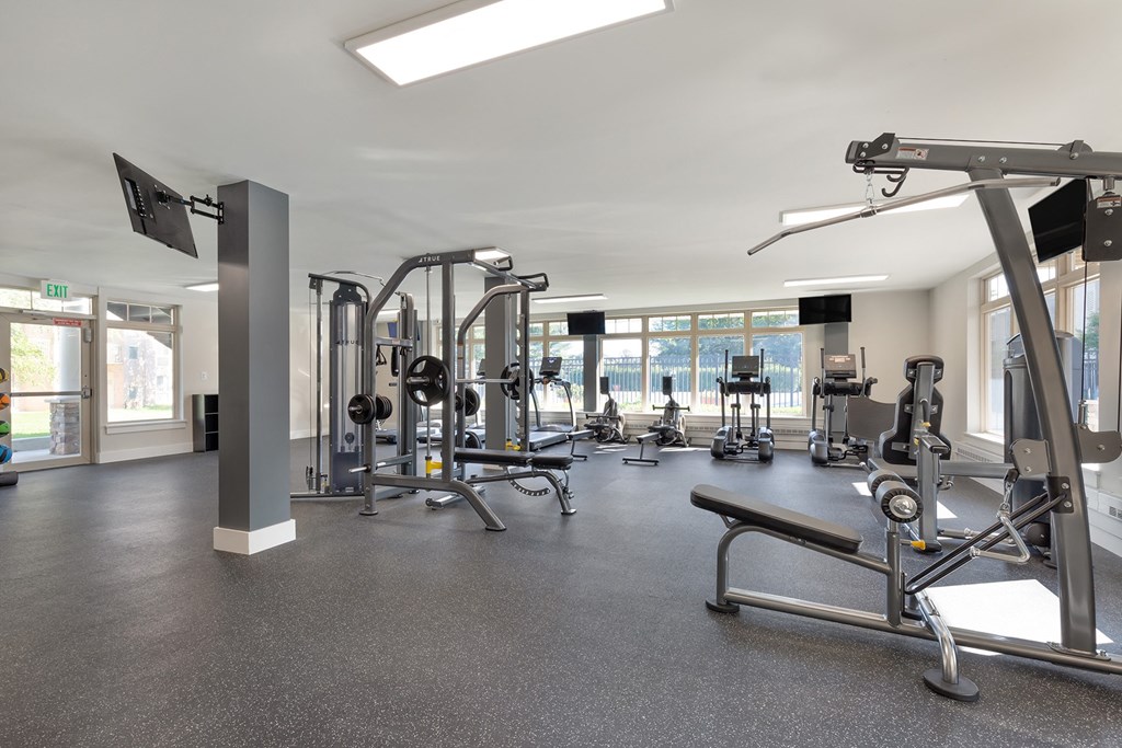 a gym with weights and other exercise equipment in a building with windows at Copper and Quarry Village, Pikesville