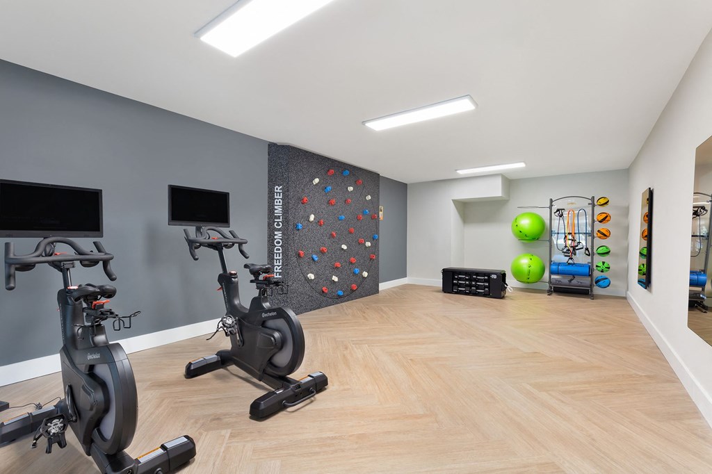 a gym with exercise machines and a rock climbing wall at Copper and Quarry Village, Maryland, 21209