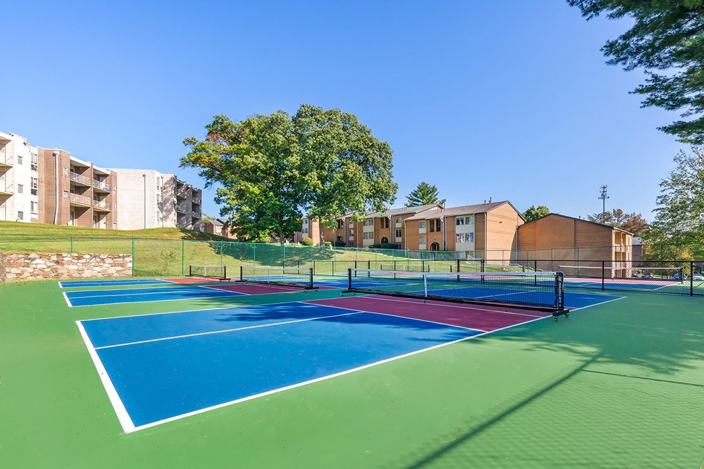tennis courts with apartments in the background at Copper and Quarry Village, Pikesville