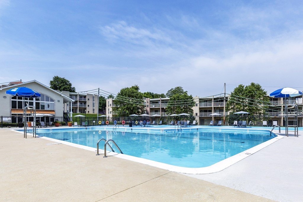 a swimming pool with umbrellas and buildings in the background at Copper and Quarry Village, Pikesville