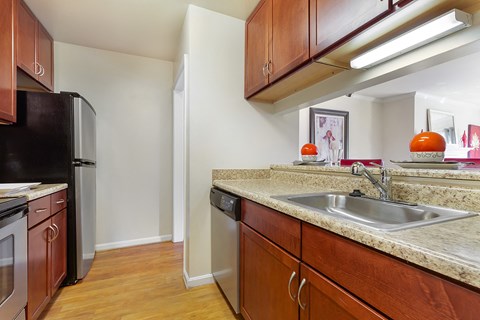 A kitchen with wooden cabinets and a black refrigerator.