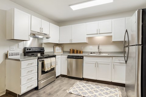 a kitchen with white cabinets and stainless steel appliances