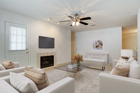 a living room with a ceiling fan and a television
