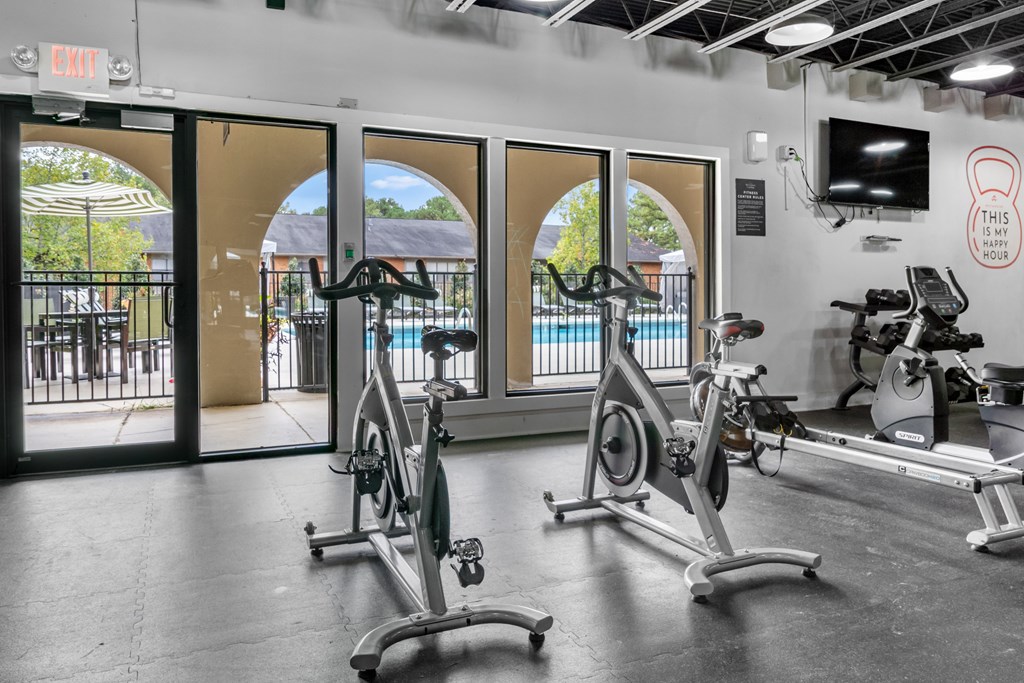 A gym with exercise bikes and a television.