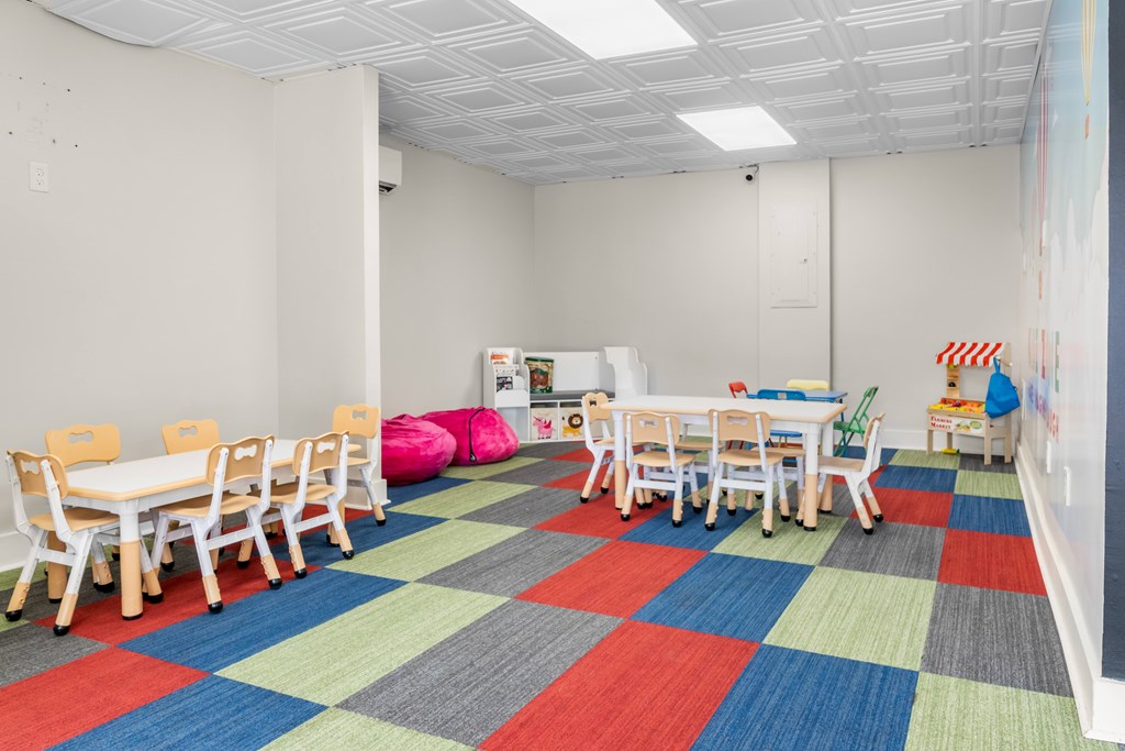A room with a white table and chairs with a colorful carpet.