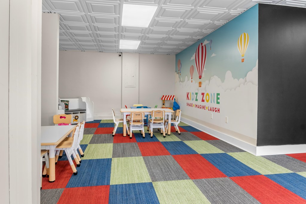 A room with a colorful carpet and a mural of hot air balloons on the wall.