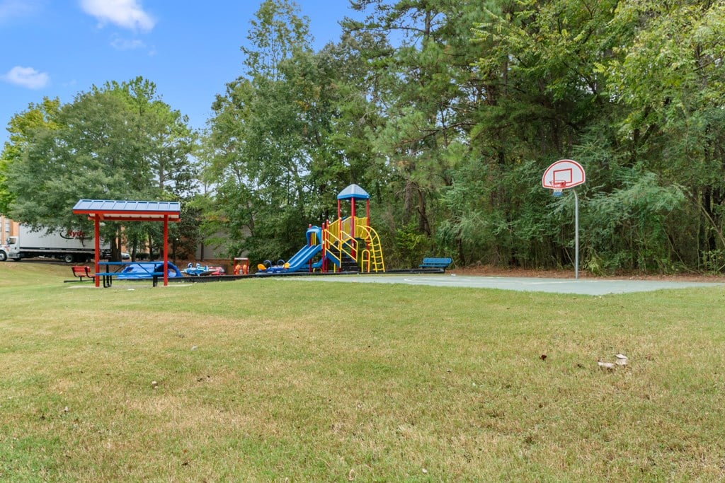 A playground with a slide and a no ball sign.