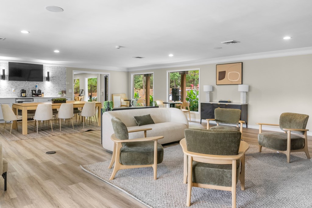 A living room with a grey rug and wooden furniture.