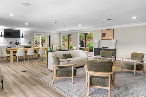 A living room with a grey rug and wooden furniture.