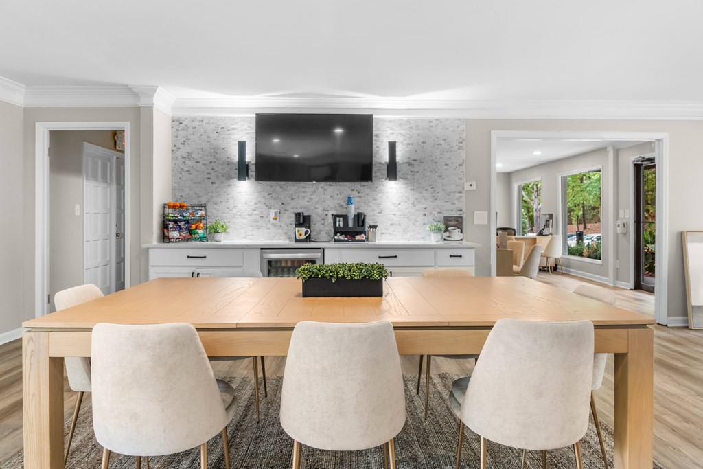 A modern kitchen with a wooden dining table and chairs.