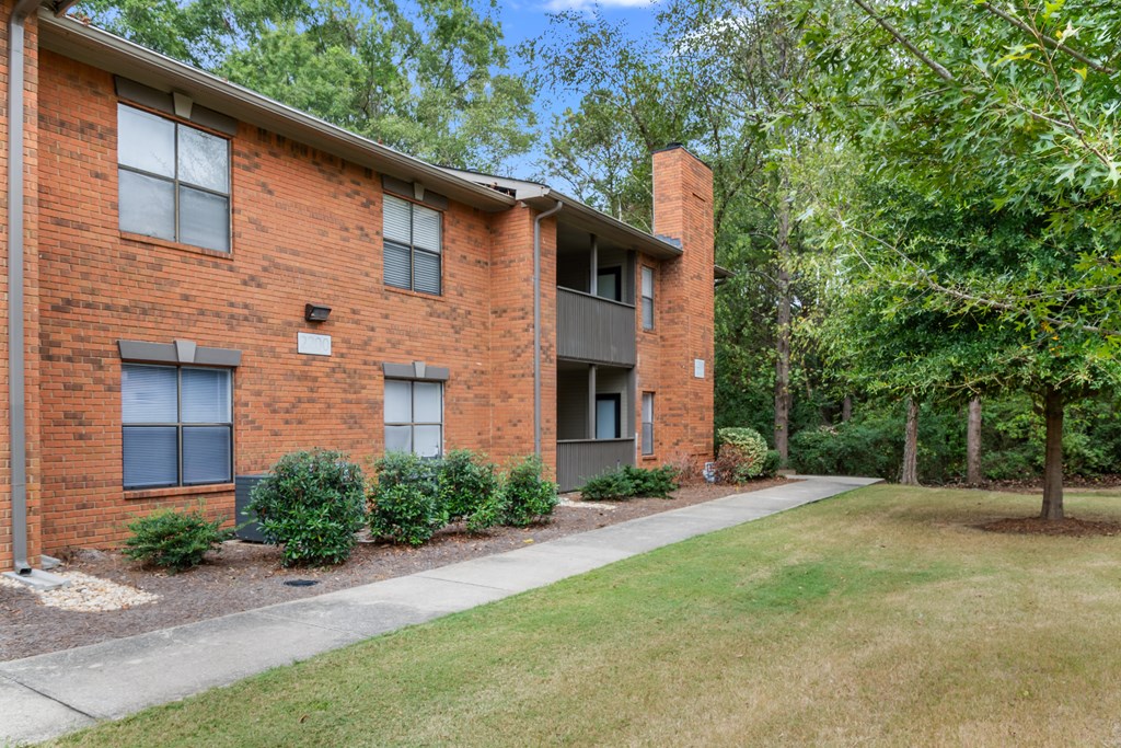 A red brick building with a green lawn in front.