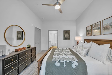 A bedroom with a large bed and a dresser.