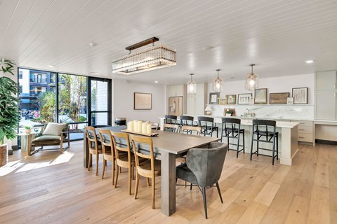 A modern dining room with a long table and chairs.