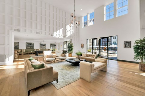 A living room with a white wall and a large window.
