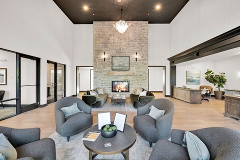 A living room with grey chairs and a fireplace.