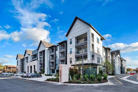 A modern apartment complex with multiple buildings and parking spaces.
