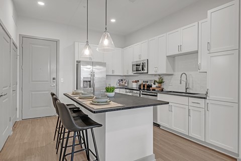 A kitchen with a table and chairs in the middle of it.