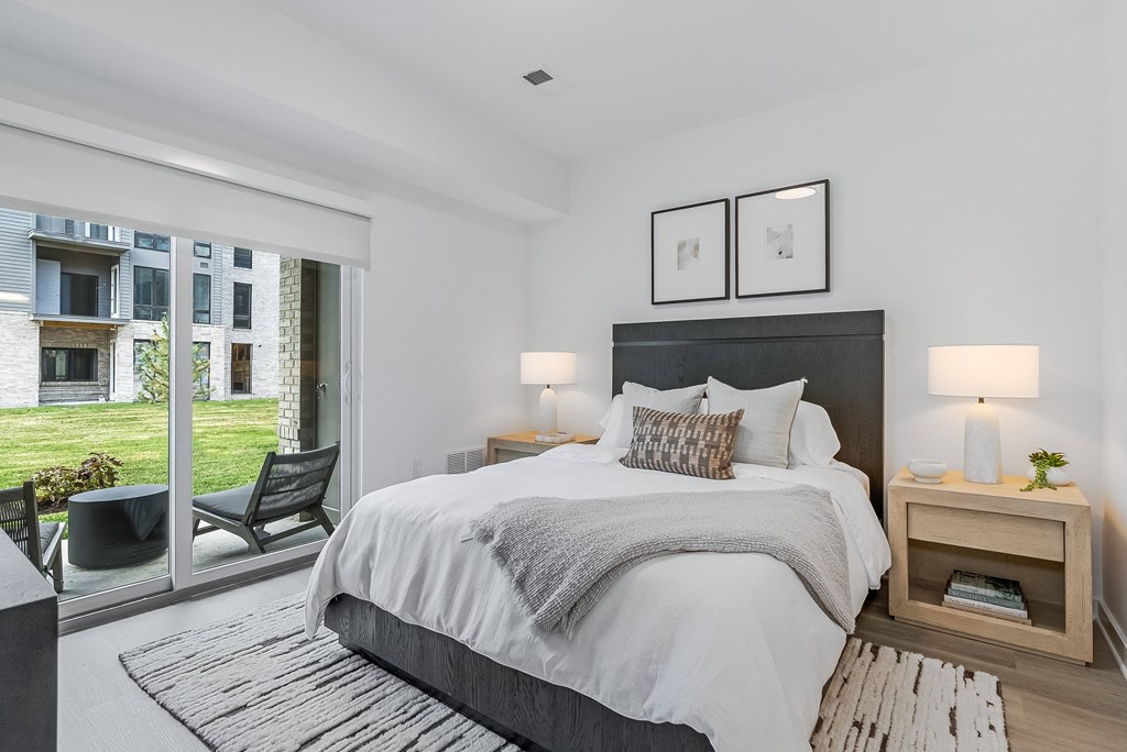 a bedroom with a large bed and a sliding glass door